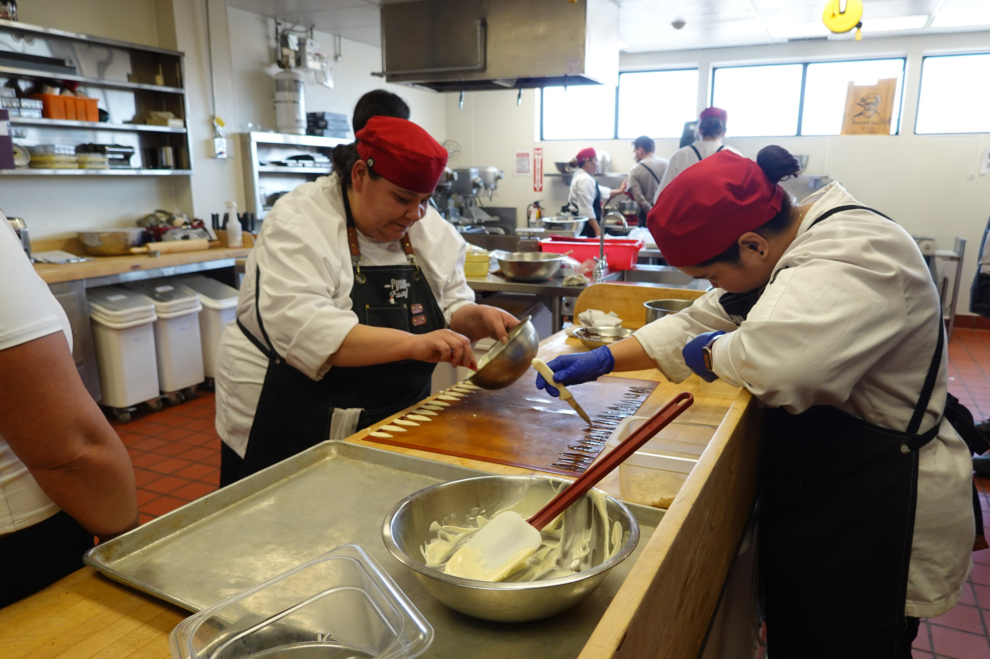 two chefs in red hat making pastries