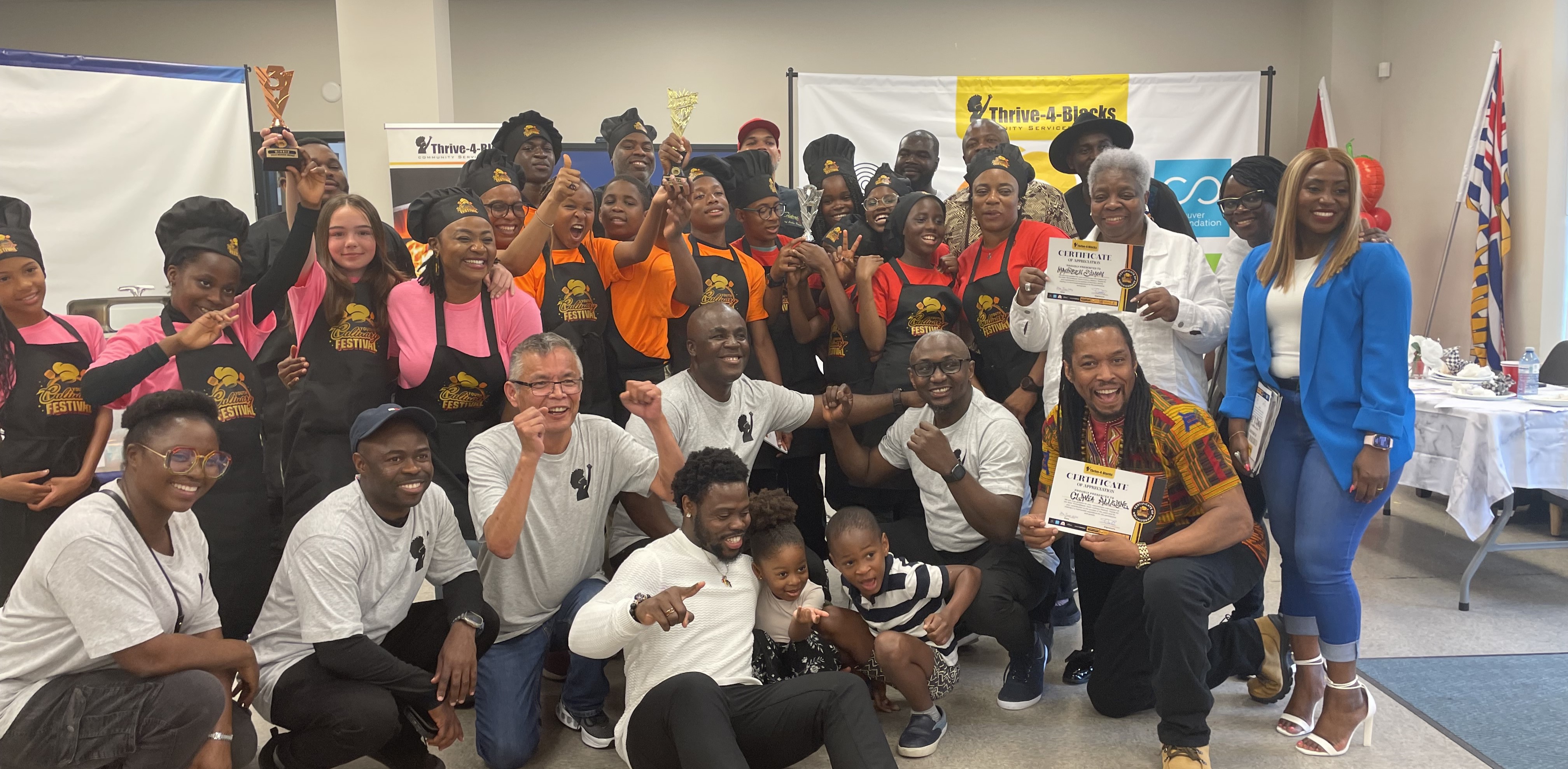 people cheering and posing for the photo holding awards and certificates