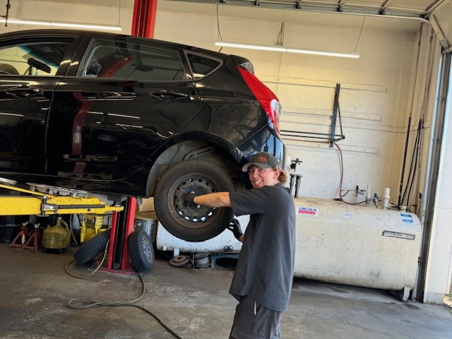 Automotive apprentice working on car