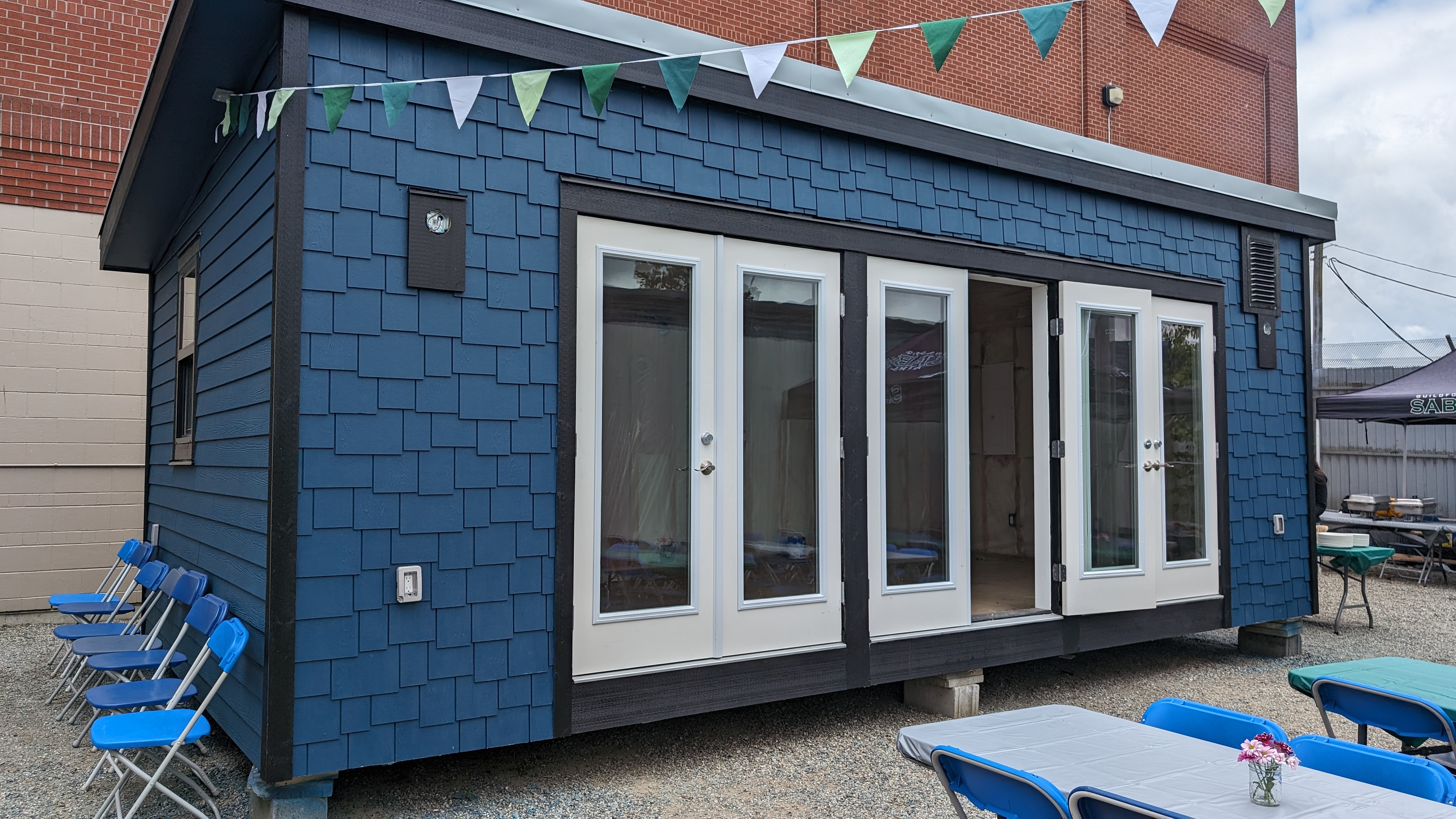 Blue tiny home with three double doors