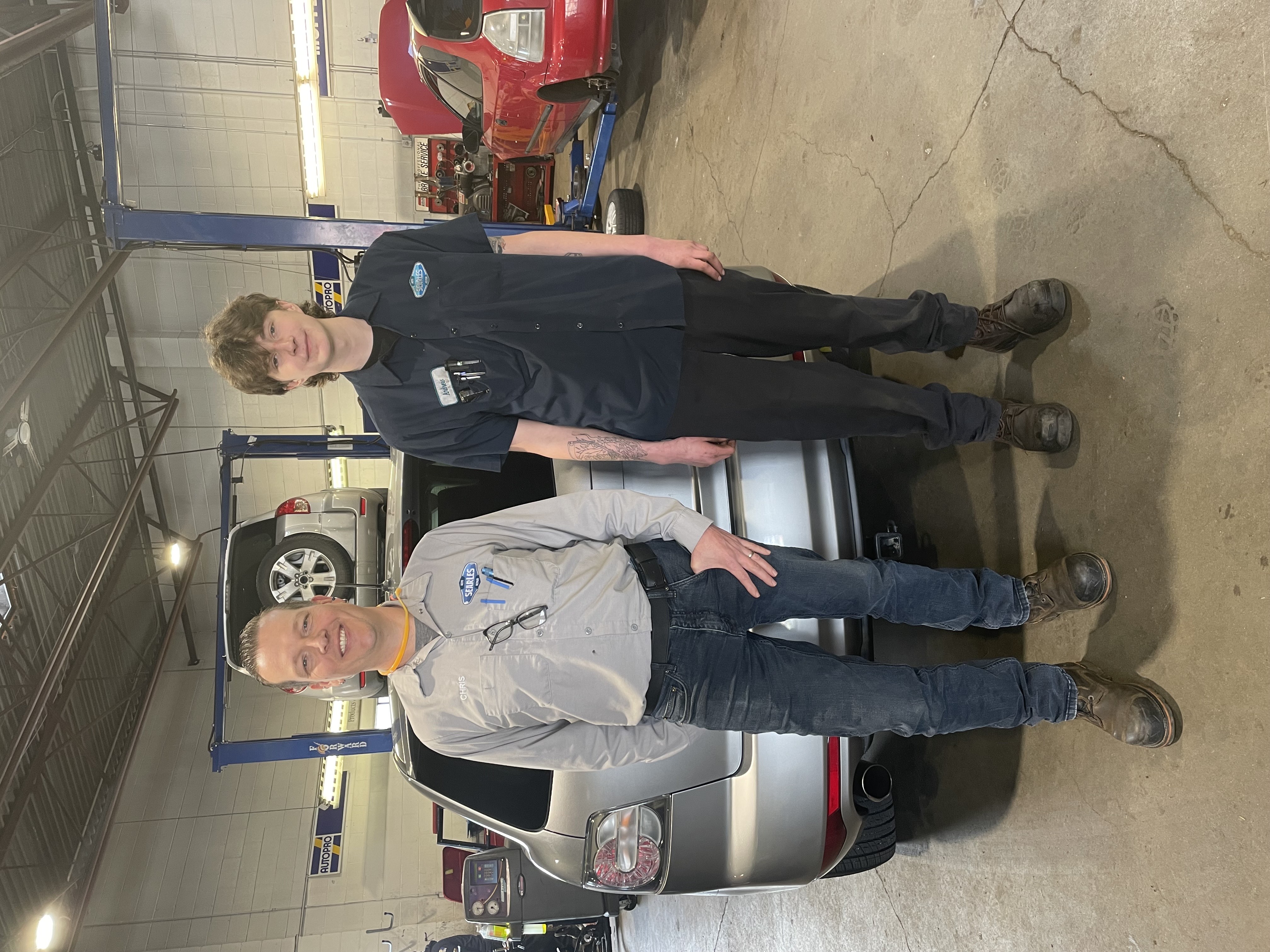 two people standing in auto shop