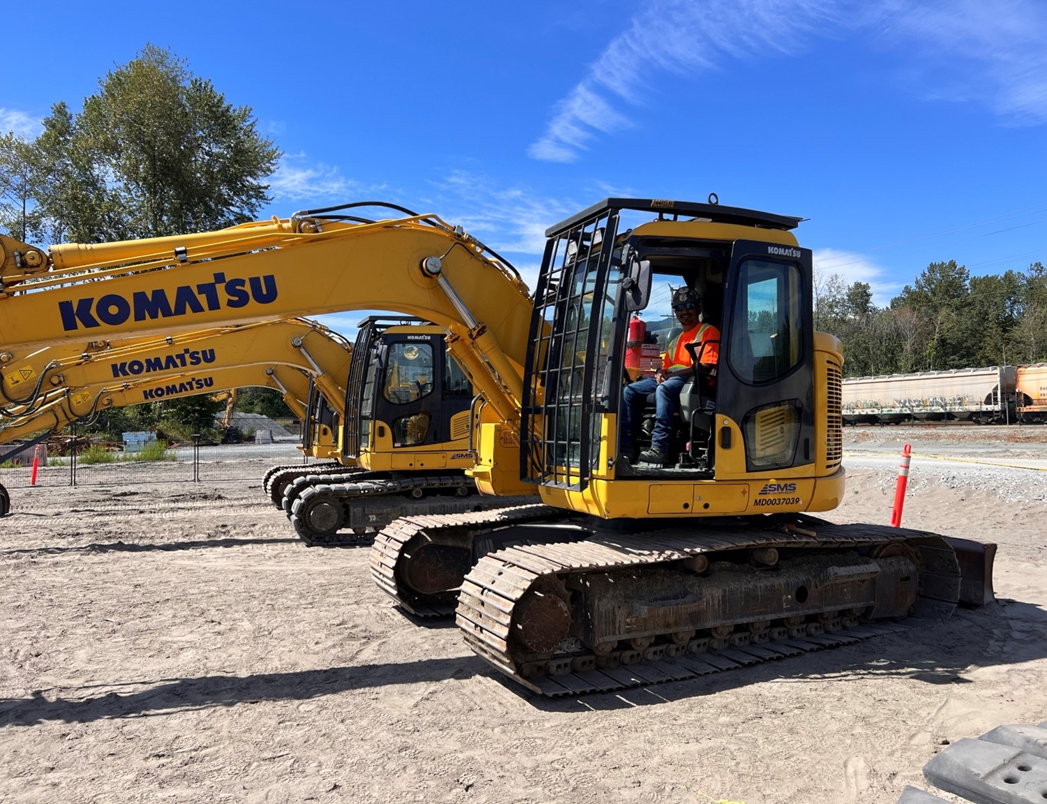 apprentice in excavator on construction site wearing ppe