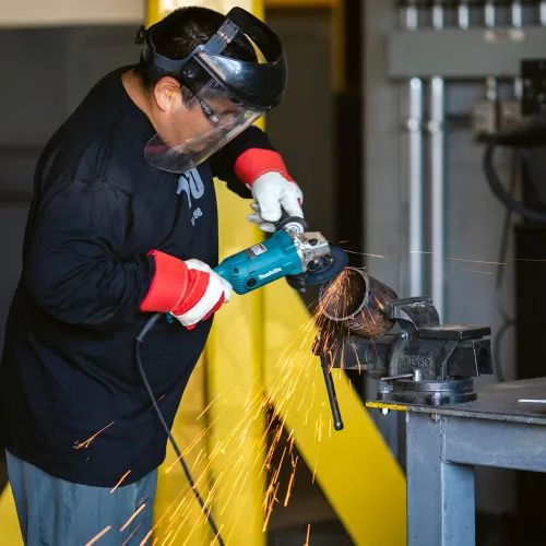 An Indigenous tradeworker working in a shop.